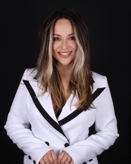 Dra. Vanessa Scheffer, cirurgiã-dentista e diretora clínica da Odo Clínica, sorrindo de jaleco branco.